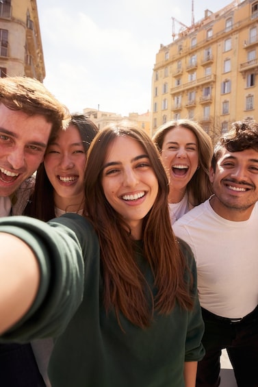 A group of people taking a selfie in an urban setting with buildings in the background. 4