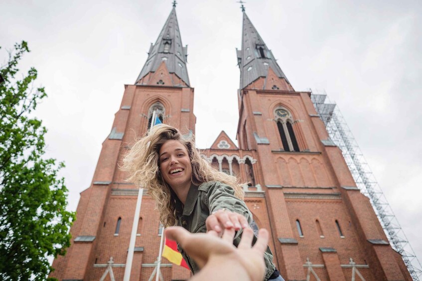 A person extending their hand towards a church with two tall spires. 3