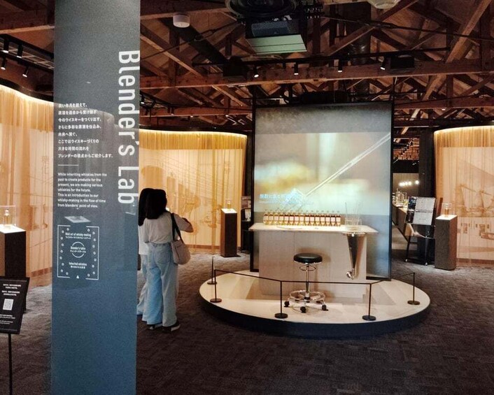 A person standing at a display with a large screen and a circular platform. 2