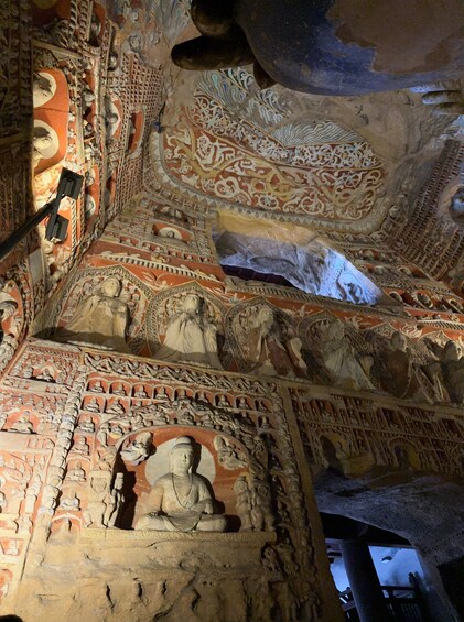 A detailed ceiling with intricate carvings and a central Buddha statue. 2