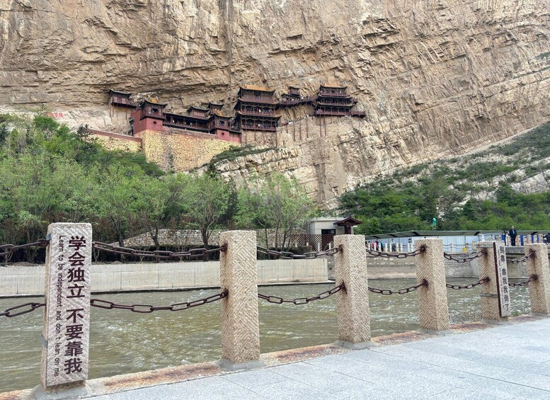 A rocky cliff with traditional Chinese architecture. 1