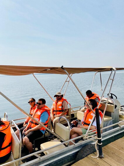 People on a boat wearing life jackets. 1