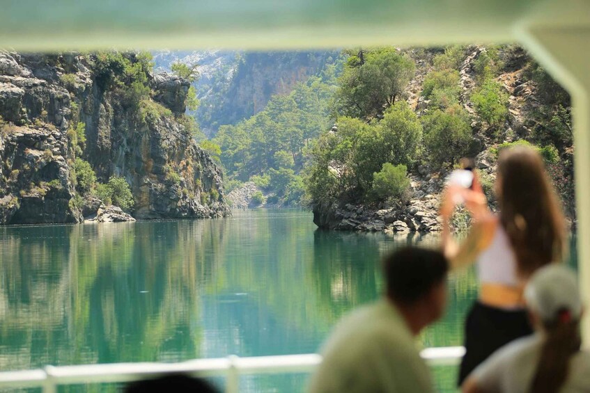 A river with rocky cliffs and greenery, viewed from a boat. 1