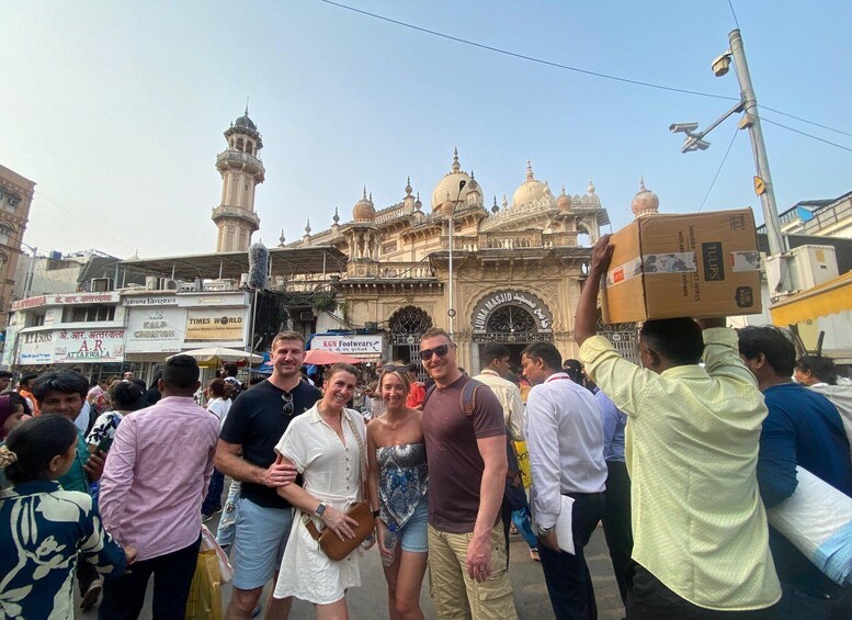 A group of people standing in front of a historic building with domes and minarets. 1
