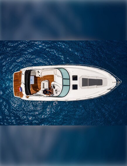 A white yacht with a wooden deck and a person standing at the bow. 5
