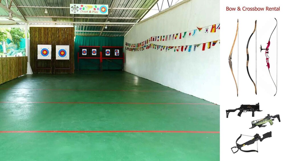 An indoor archery range with targets, a green floor, and a wall decorated with flags. 3