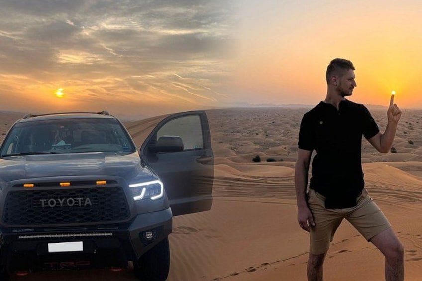 A Toyota SUV in a desert with sand dunes and a sunset in the background. 1