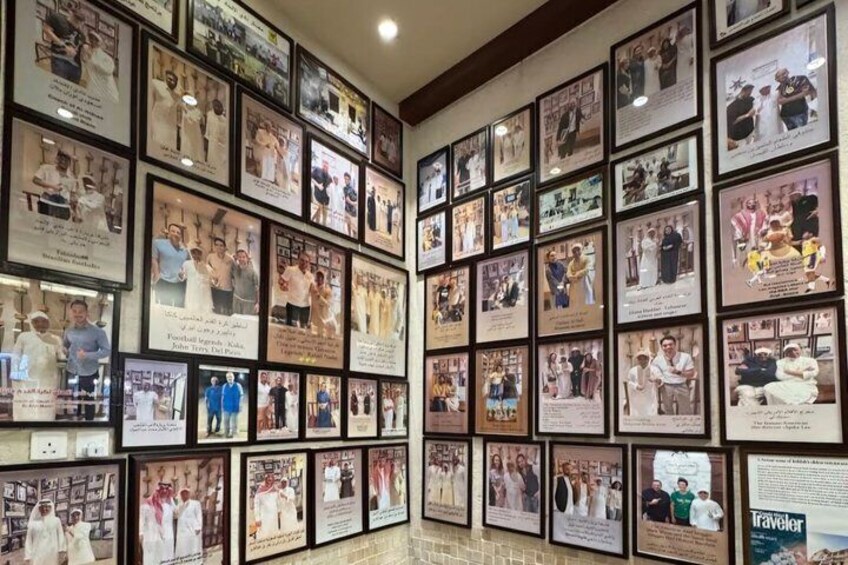 A wall of framed photographs with captions, likely in a museum or gallery setting. 5