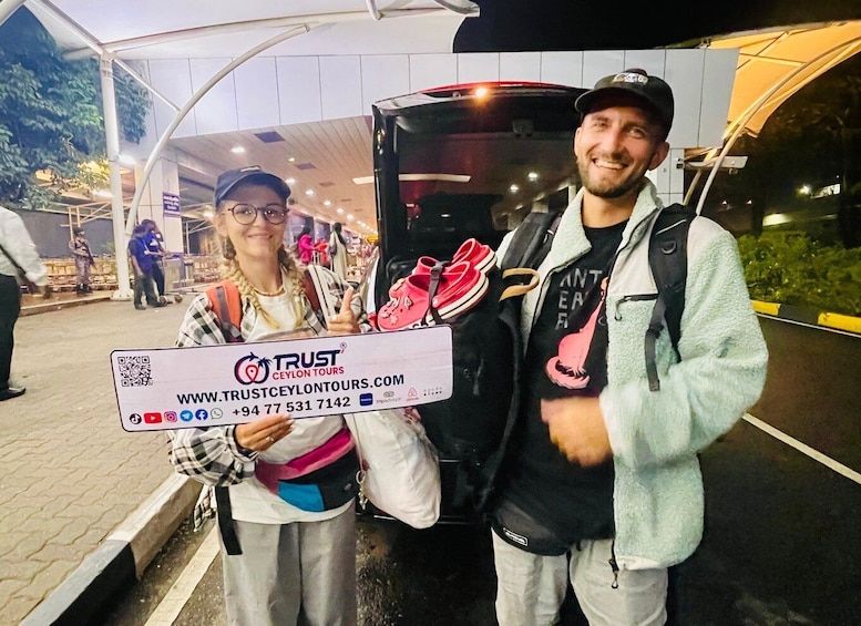 Two people holding a large check in front of a vehicle. 3
