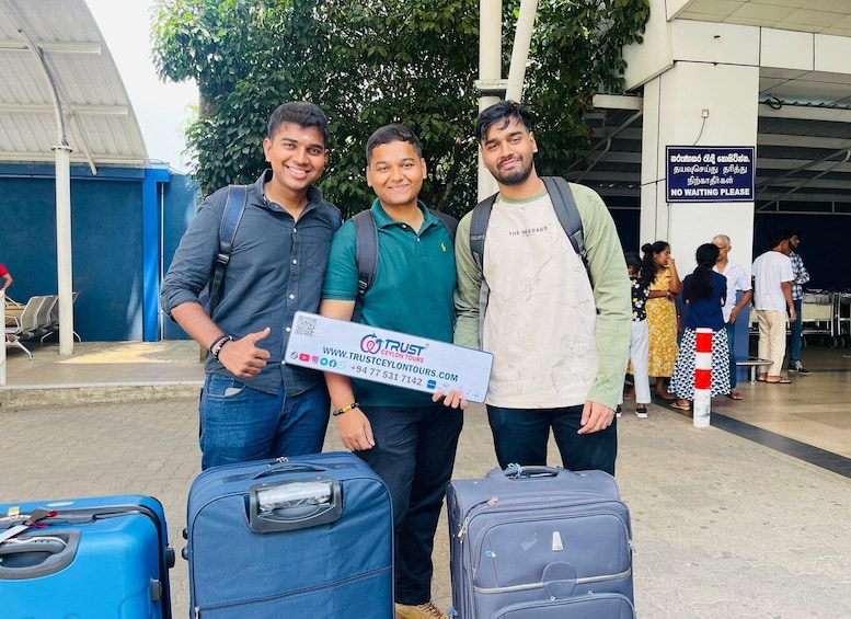 Three people standing in front of luggage with a sign that reads "TRUST CEYLON TOURS". 5