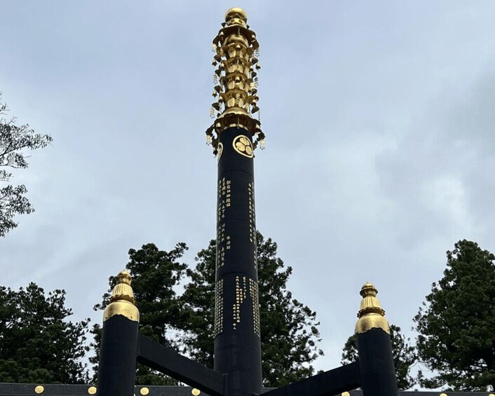 A tall, black and gold structure with a spiral design and a clock face. 2