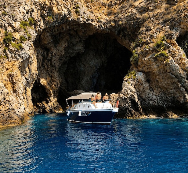 Una barca chiamata 'Cristal' vicino all'ingresso di una grotta rocciosa. 1