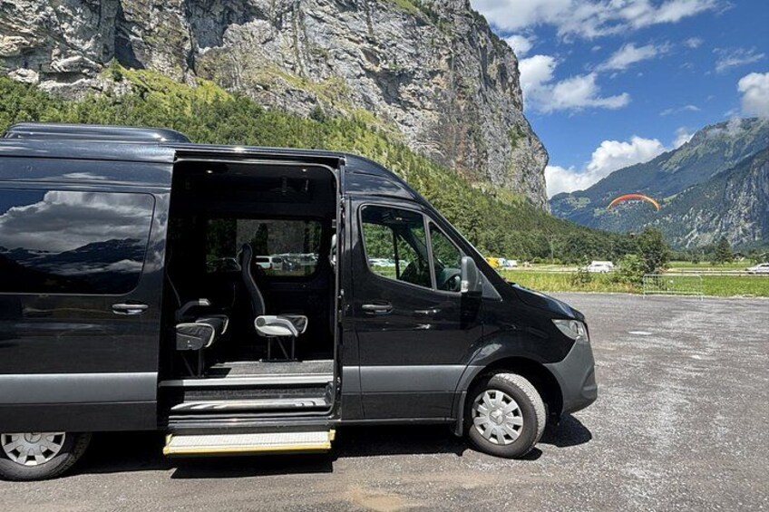 En svart skåpbil stod parkerad på en grusplan med ett bergigt landskap i bakgrunden. 2
