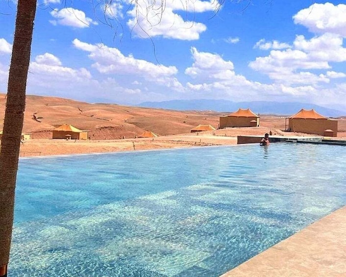 A clear blue swimming pool with a desert landscape in the background. 3