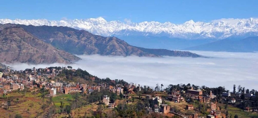 A mountainous town with snow-capped peaks in the background and a valley below. 5
