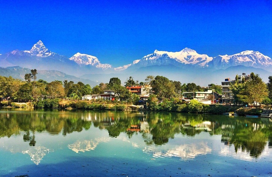 A calm lake reflecting mountains and buildings. 4