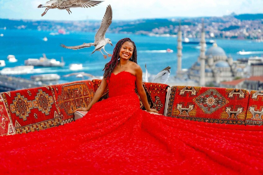 A person in a red dress with a patterned backdrop, birds flying, and a cityscape with water and boats in the background. 2