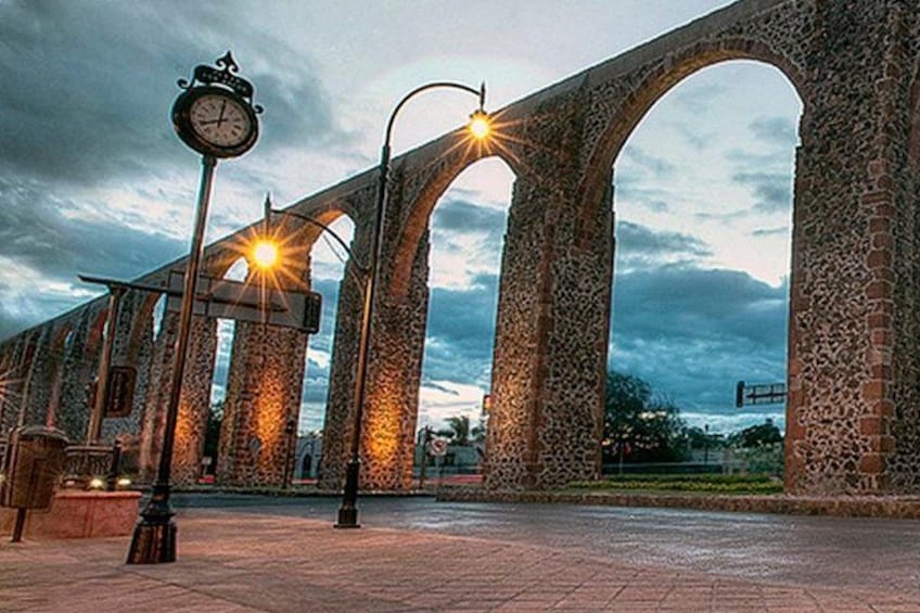Un pont en pierre avec des arches, une horloge et des lampadaires. 3