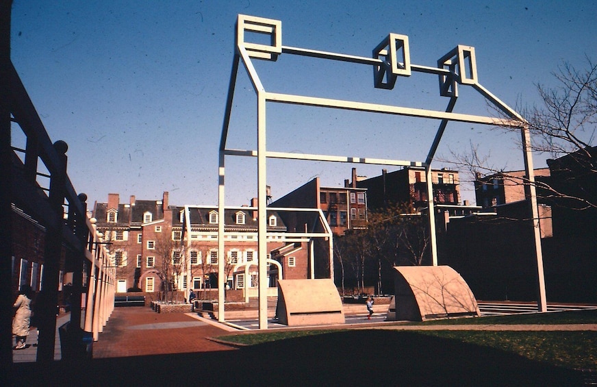 A playground with a metal climbing structure and a sandbox. 3