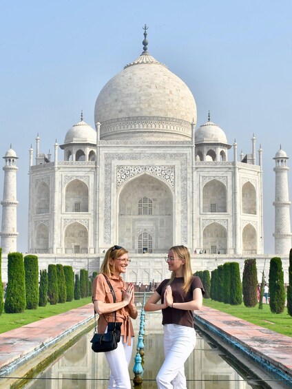 The Taj Mahal with two people standing in front of it. 1