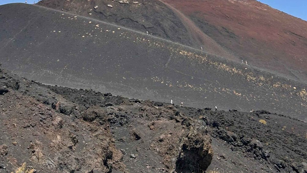 Eine vulkanische Landschaft mit einem markanten Krater und verstreuten Felsen. 2