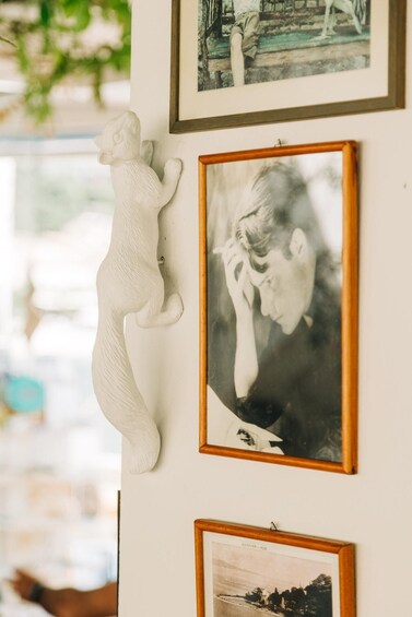 A wall with framed photographs and a white sculpture. 3