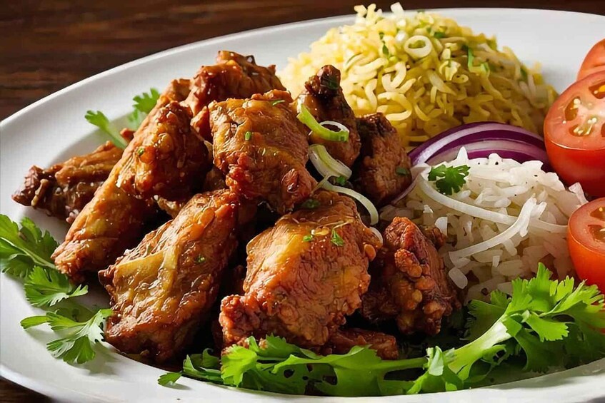 A plate of fried chicken, rice, and vegetables. 2