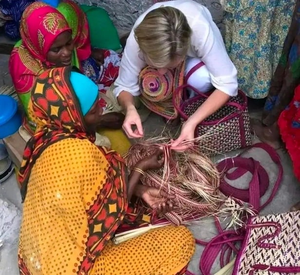Women engaged in weaving with colorful textiles and tools. 3