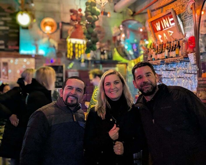 A bar with a 'WINE BAR' sign, bottles, and hanging decorations. 2