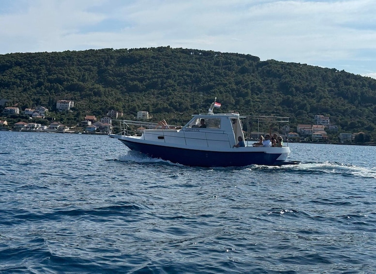 A boat on a body of water with a hilly landscape in the background. 1