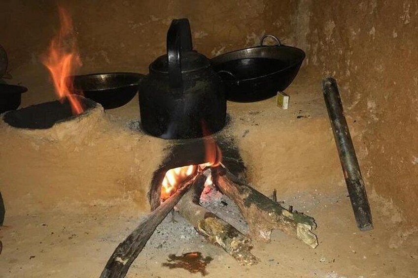 En traditionell matlagningsplats med kastruller och en lång träpinne. 2