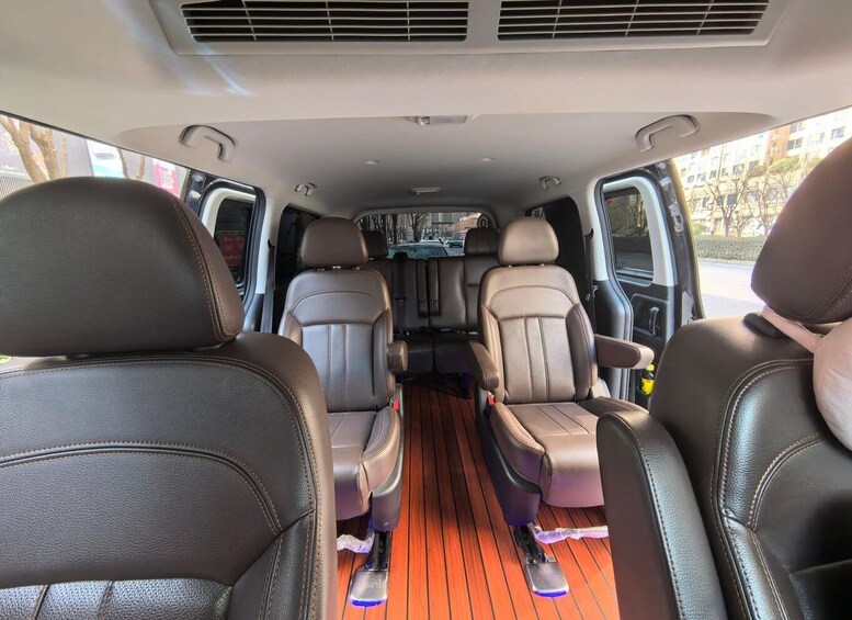 A vehicle interior with leather seats, a wooden floor, and a central console. 3