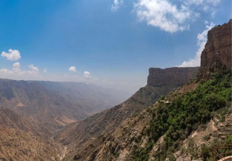 A canyon with steep cliffs and sparse vegetation. 1