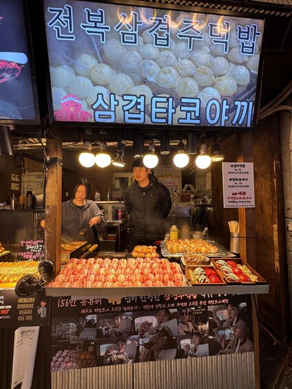 A food stall with various snacks and a signboard. 3