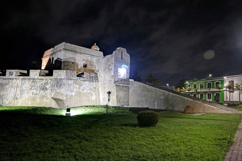 A historic fort with a tower, surrounded by well-maintained grass and a paved path. 1