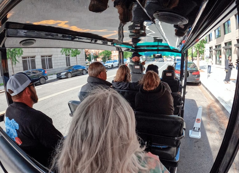 Matkustajat bussissa, josta avautuu näkymä kaupungin kadulle. 4