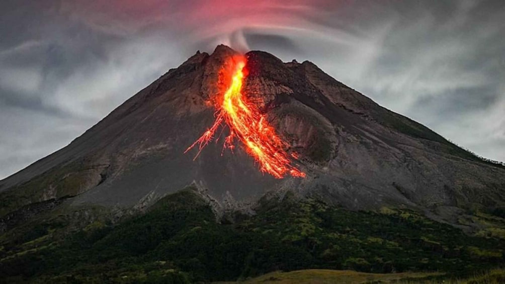 A volcano with lava flowing down its side. 1