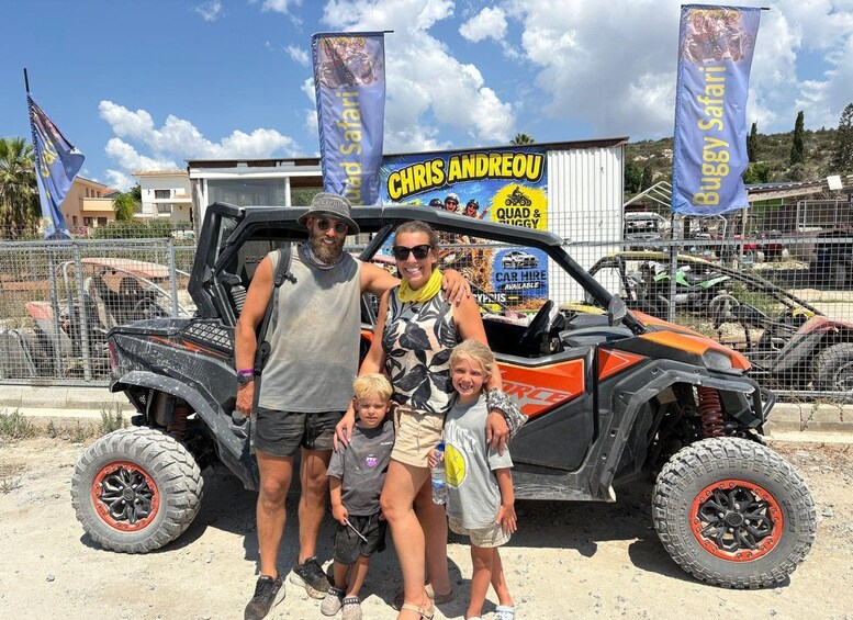 A family posing in front of a quad bike with a banner reading 'CHRIS ANDREOU' and 'Buggy Safari'. 4
