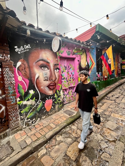 A street with colorful murals, a person walking, and a building with a red roof. 5