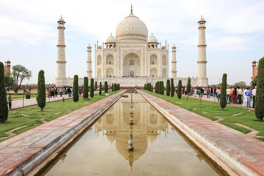Le Taj Mahal se reflète dans l’eau, entouré de jardins parfaitement entretenus et de minarets. 5