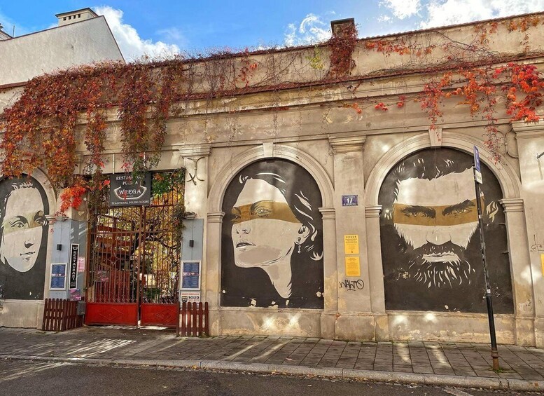 A building with large murals, a gated entrance, and ivy-covered walls. 4