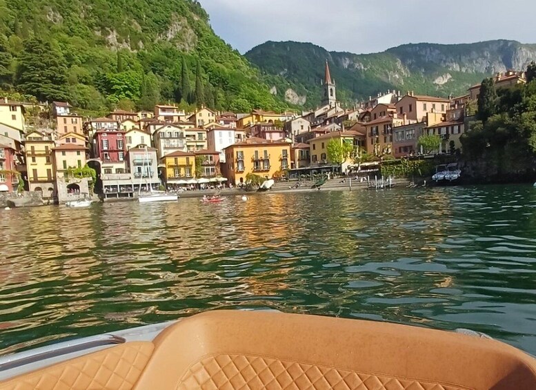 A boat on a calm river with colorful buildings and a church on the hillside. 3
