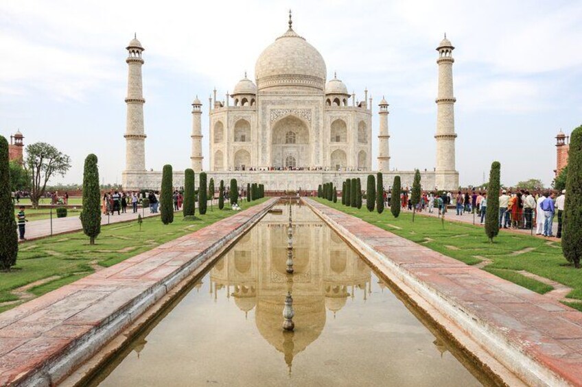 De Taj Mahal met een centraal reflectiebad, vier minaretten en een symmetrische tuinindeling. 3