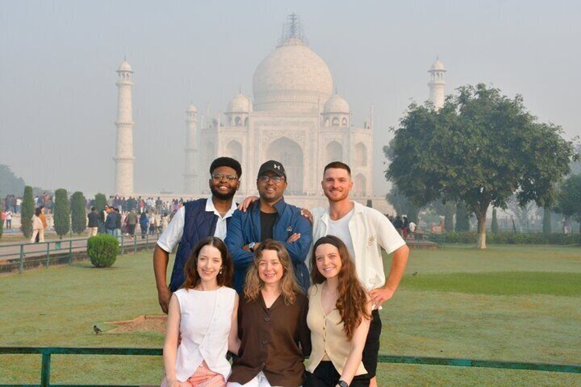 A group of people standing in front of the Taj Mahal. 1