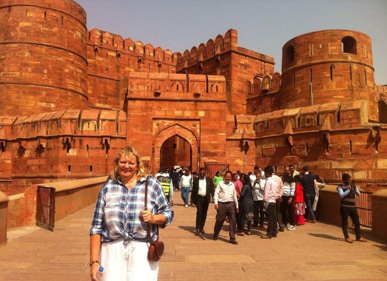 A historic fort with red stone walls and a large arched entrance. 2