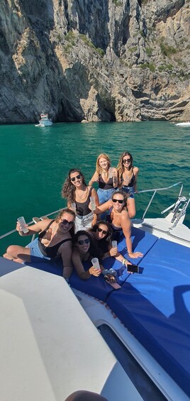 A group of people on a boat with a rocky coastline in the background. 4
