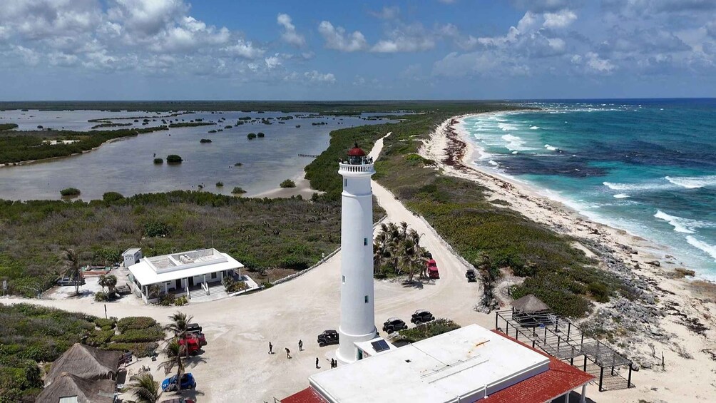 A coastal area with a lighthouse, beach, and surrounding vegetation. 1