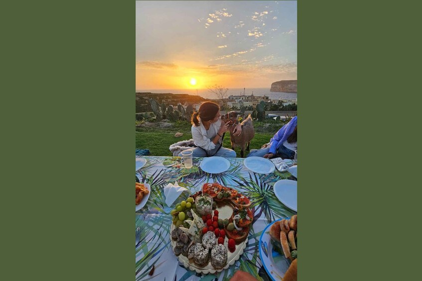 A sunset over a coastal landscape with people enjoying a picnic. 1