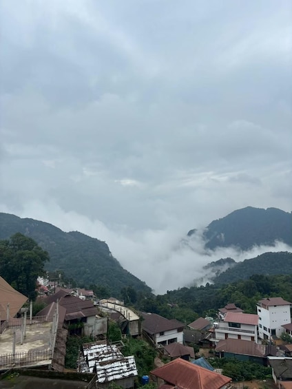 A mountainous landscape with a village nestled in the valley, surrounded by lush greenery and mist-covered peaks. 3