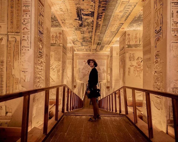 A corridor with hieroglyphs on the walls and ceiling, leading to a staircase. 1